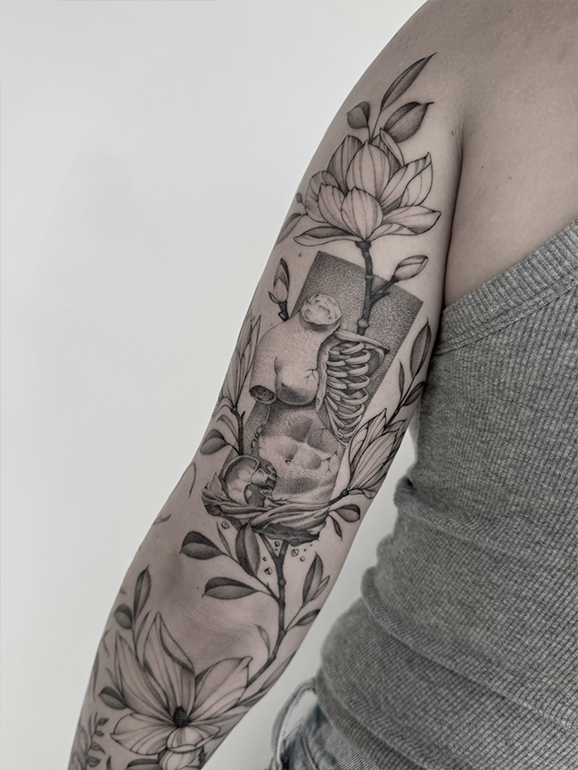 human torso and flowers tattoo on arm