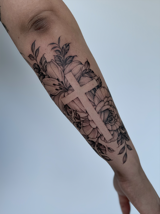 cross and flowers tattoo on arm