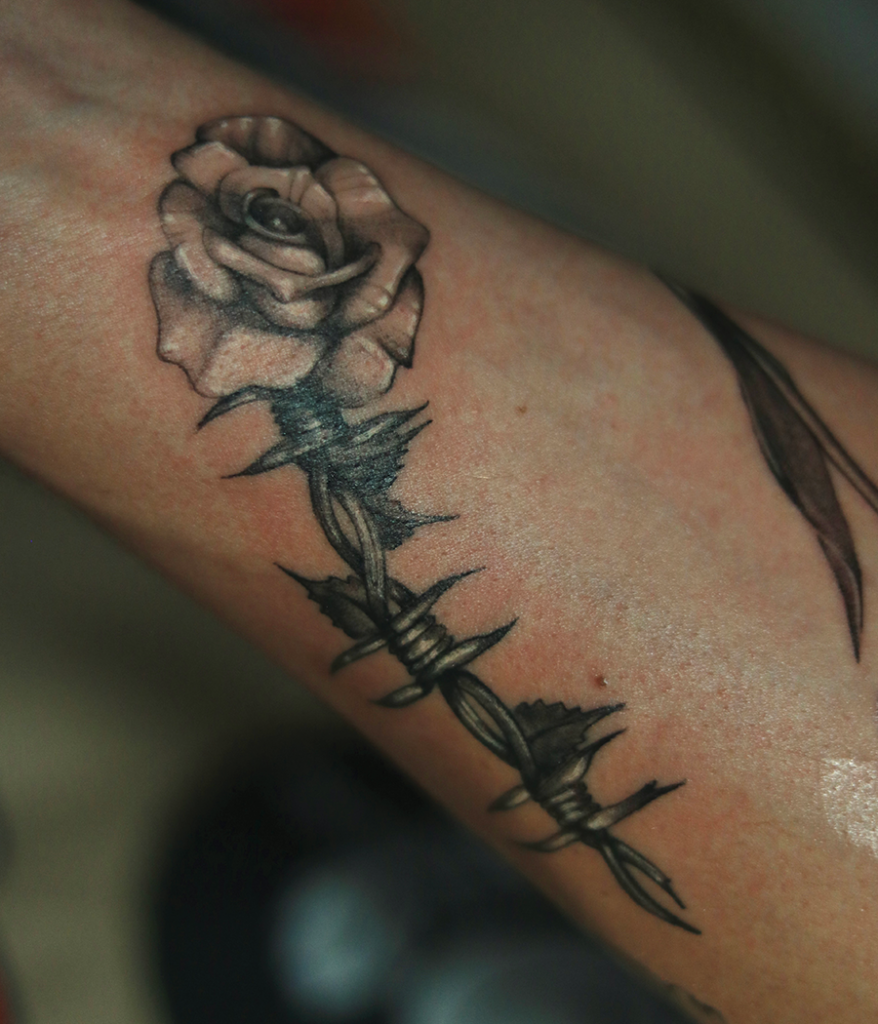 rose and barb wire tattoo on arm