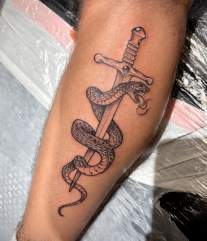 sword and snake tattoo on leg