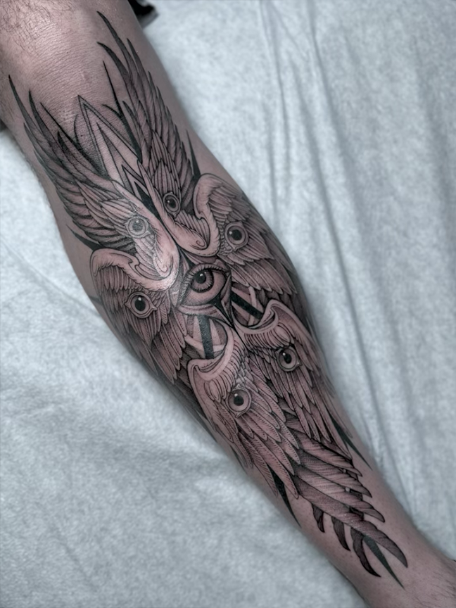 wings and eyes tattoo on arm leg
