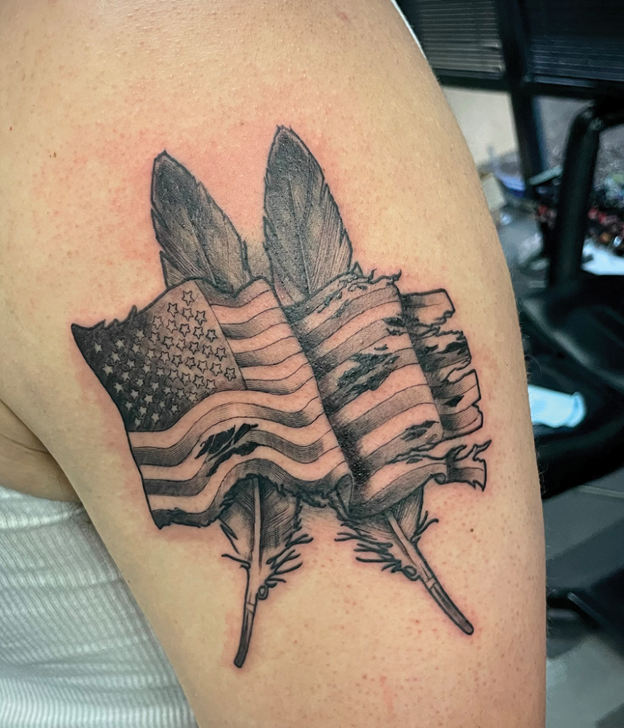 american flag and feathers tattoo on arm