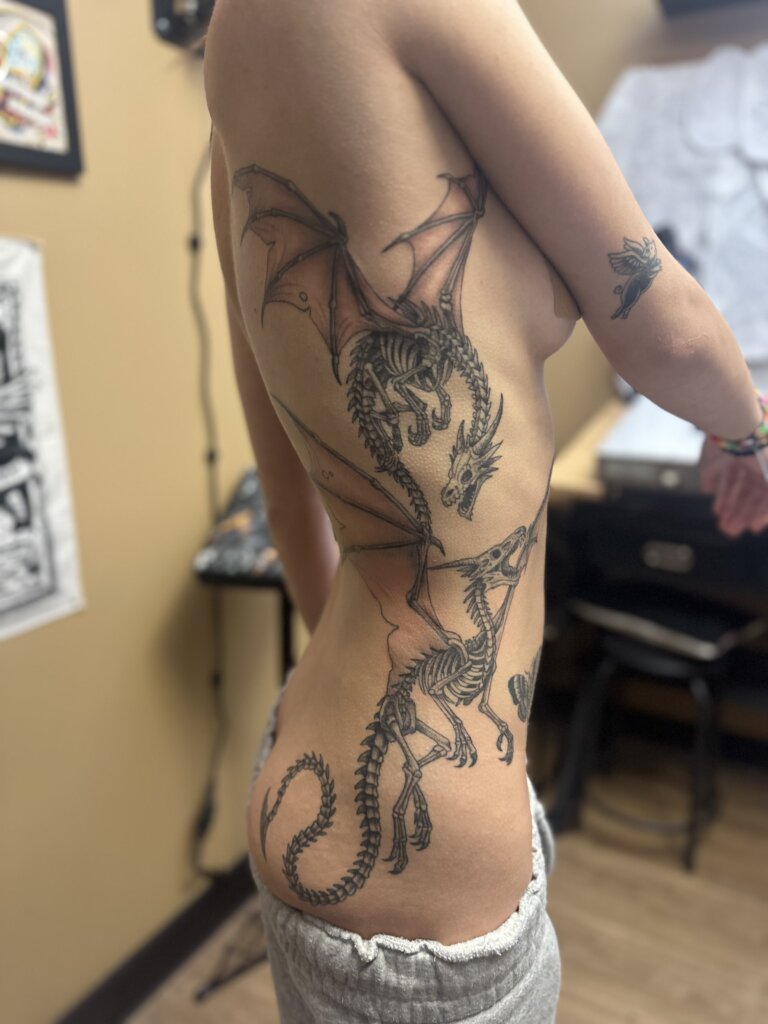 dragon skeleton tattoo on side of body