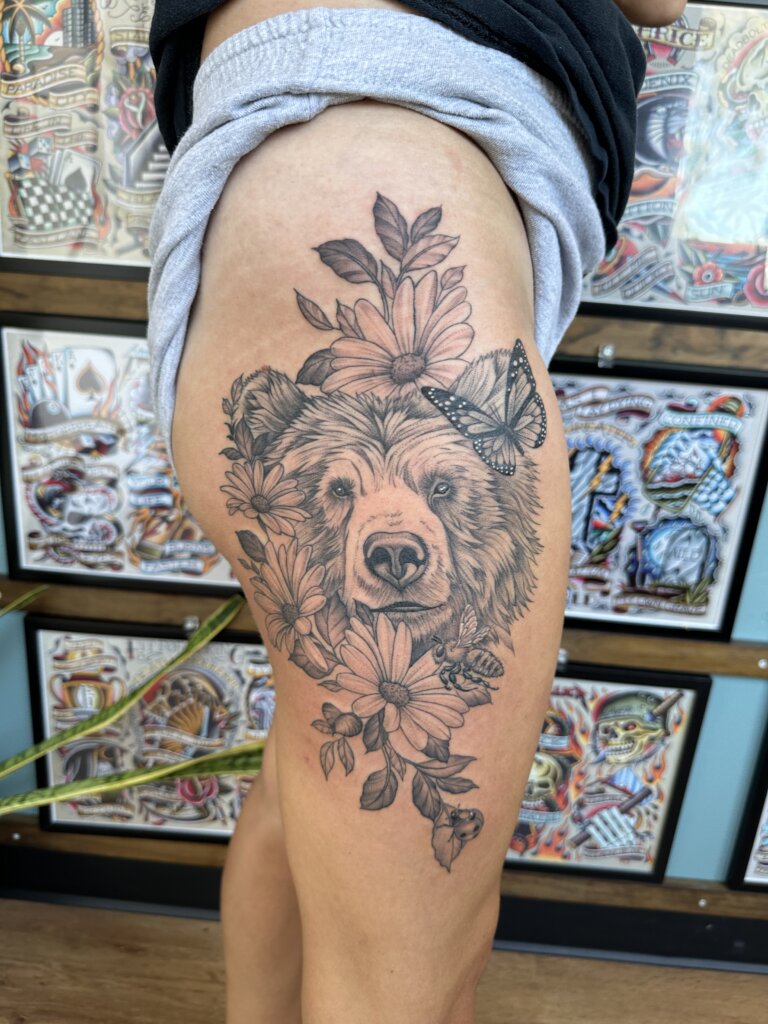 bear and flowers tattoo on thigh