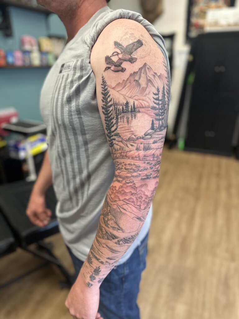 mountain scene tattoo on full arm