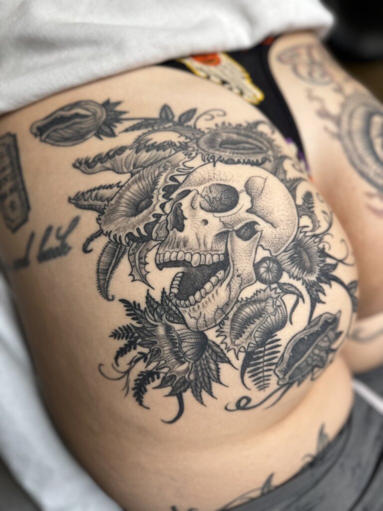 skull and plants tattoo on glute