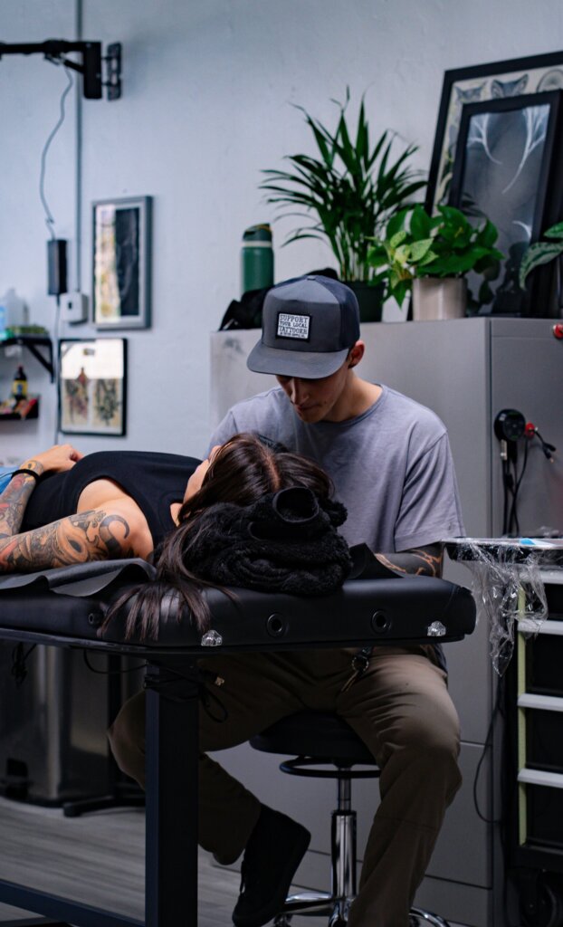 Tattoo artist working on client
