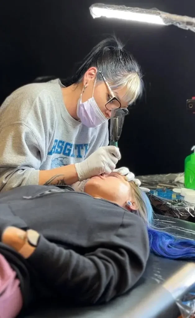 tattoo artist working on client