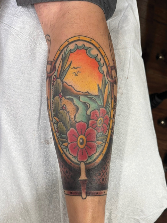 mountain scene in a frame tattoo on leg