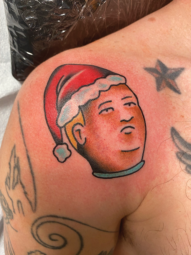 tv show character tattoo on shoulder in santa hat