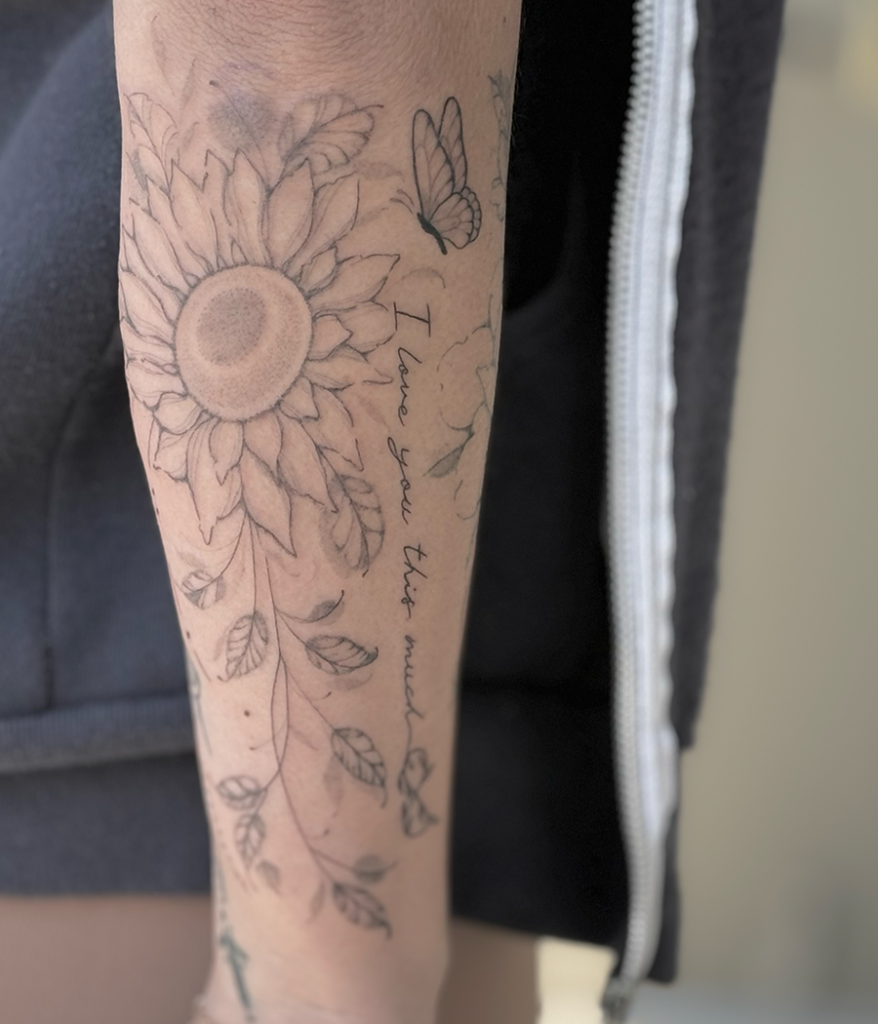 flower and script tattoo on arm