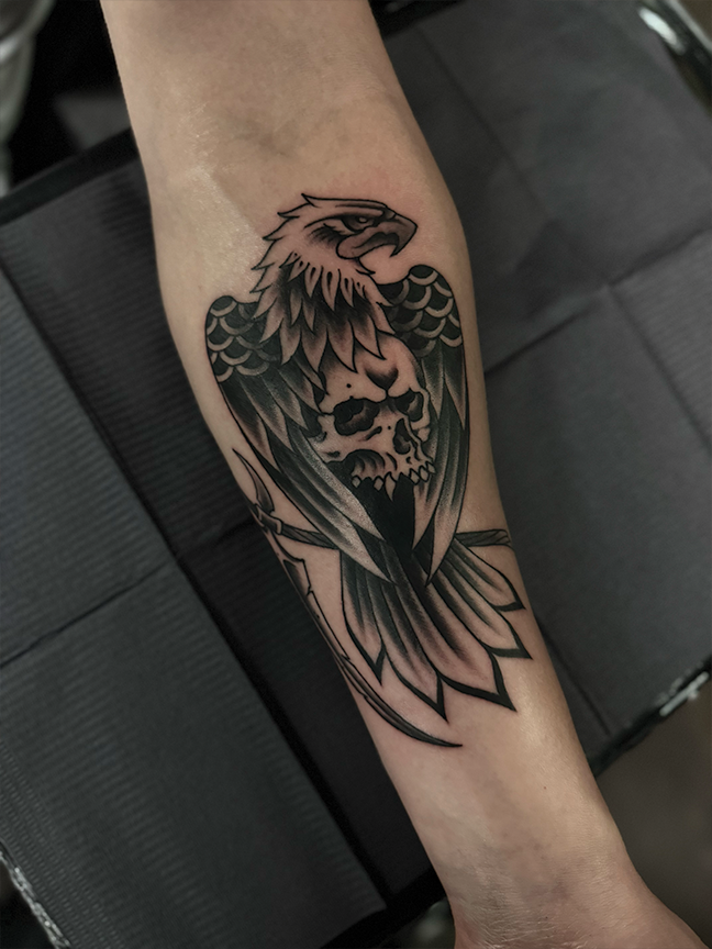 eagle sitting on a skull tattoo on arm