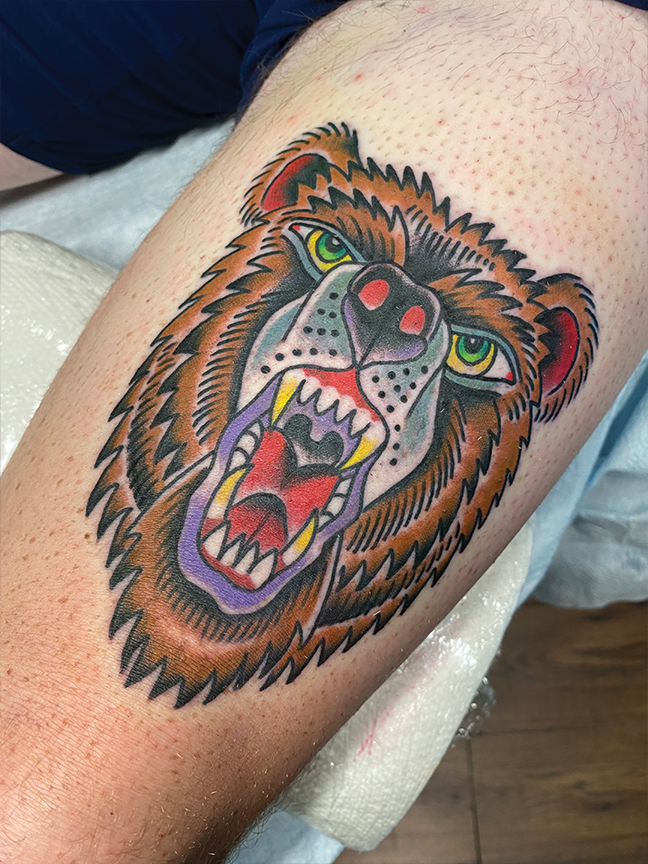 bear face tattoo on leg