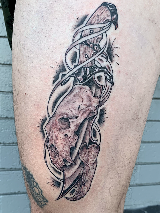 sword and animal skull tattoo on leg