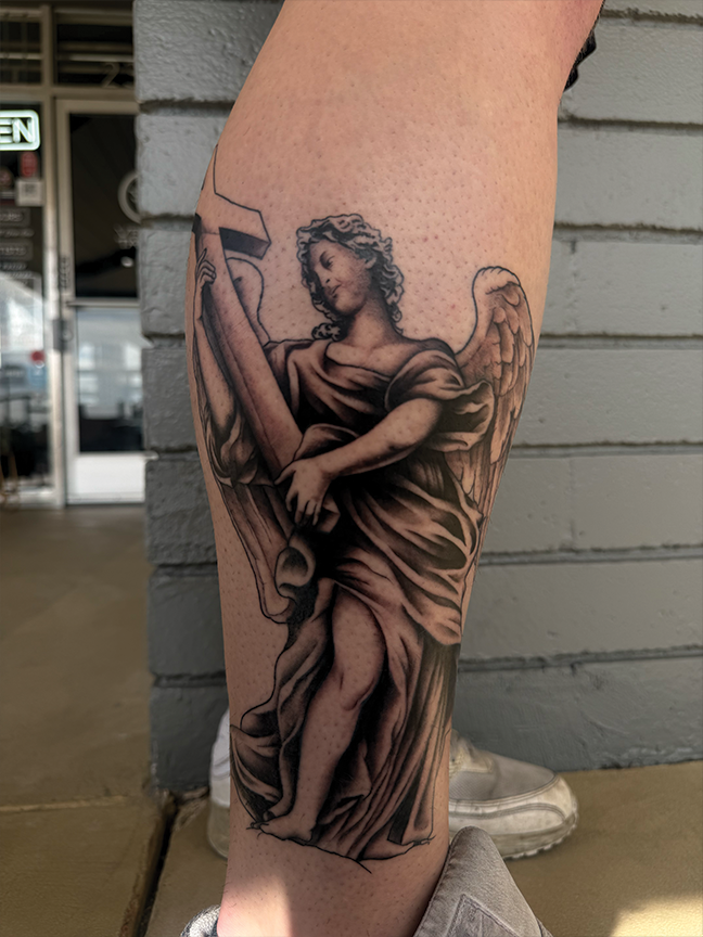 angel and cross tattoo on leg