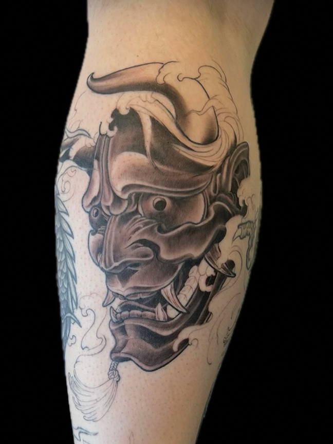 horned character tattoo on leg