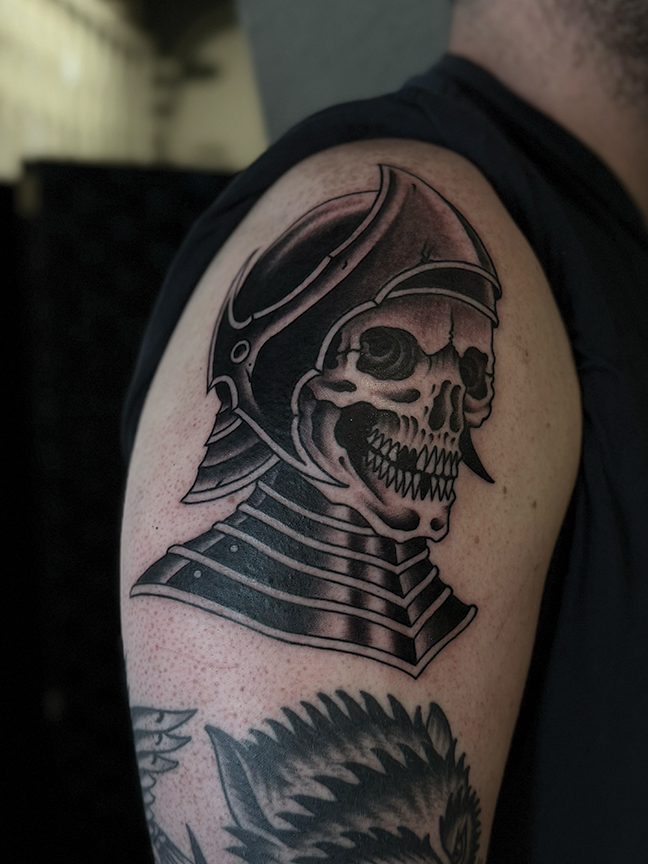 skull in armor tattoo on arm