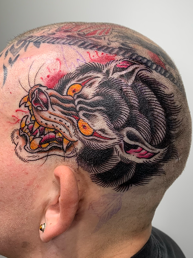 wolf tattoo on top of a mans head