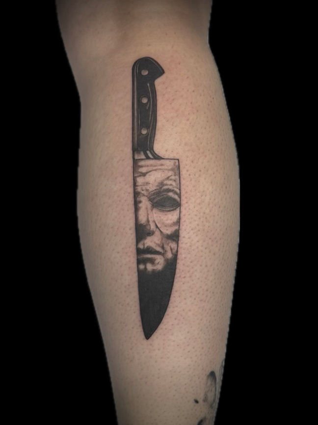 portrait and sword tattoo on leg