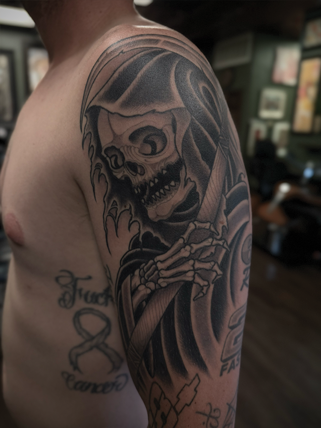 skull in cloak tattoo on shoulder