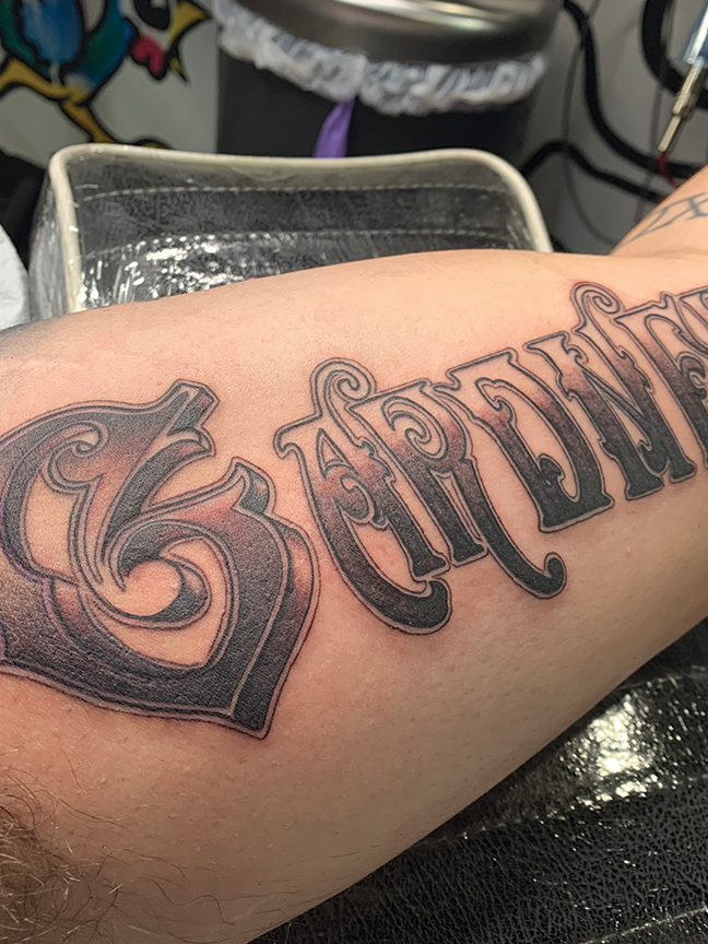 Script lettering tattoo on arm