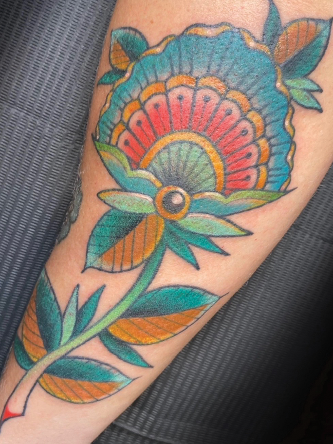 shell flower tattoo on arm