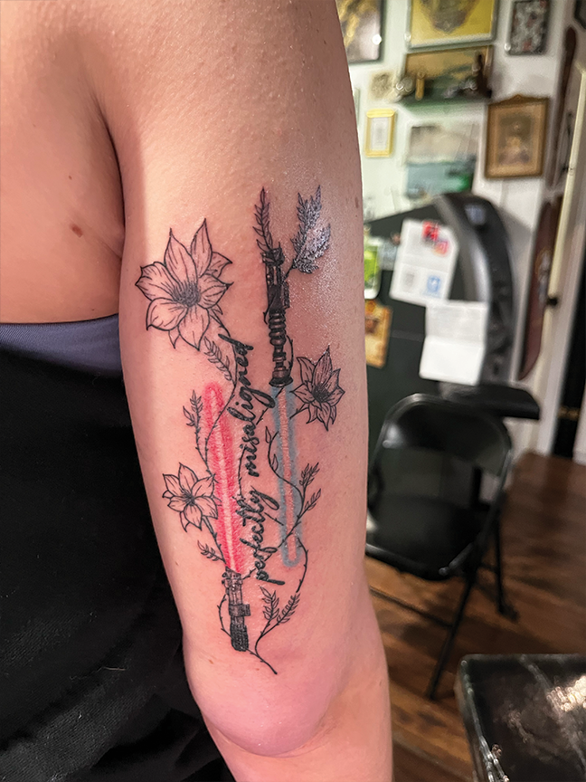 light saber and blossom tattoo on arm