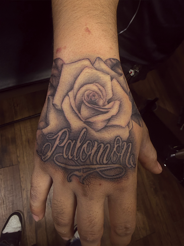 rose and script writing tattoo on hand