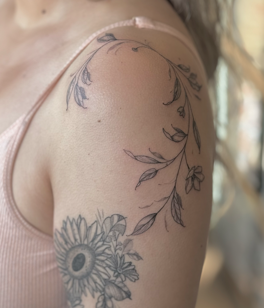 fine line floral tattoo on shoulder
