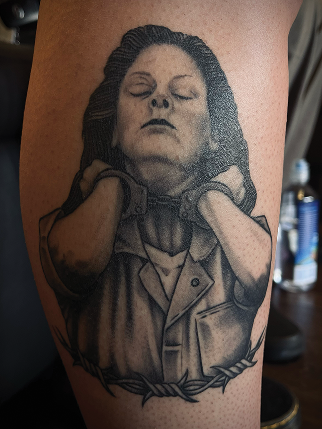 female portrait in handcuffs tattoo on leg