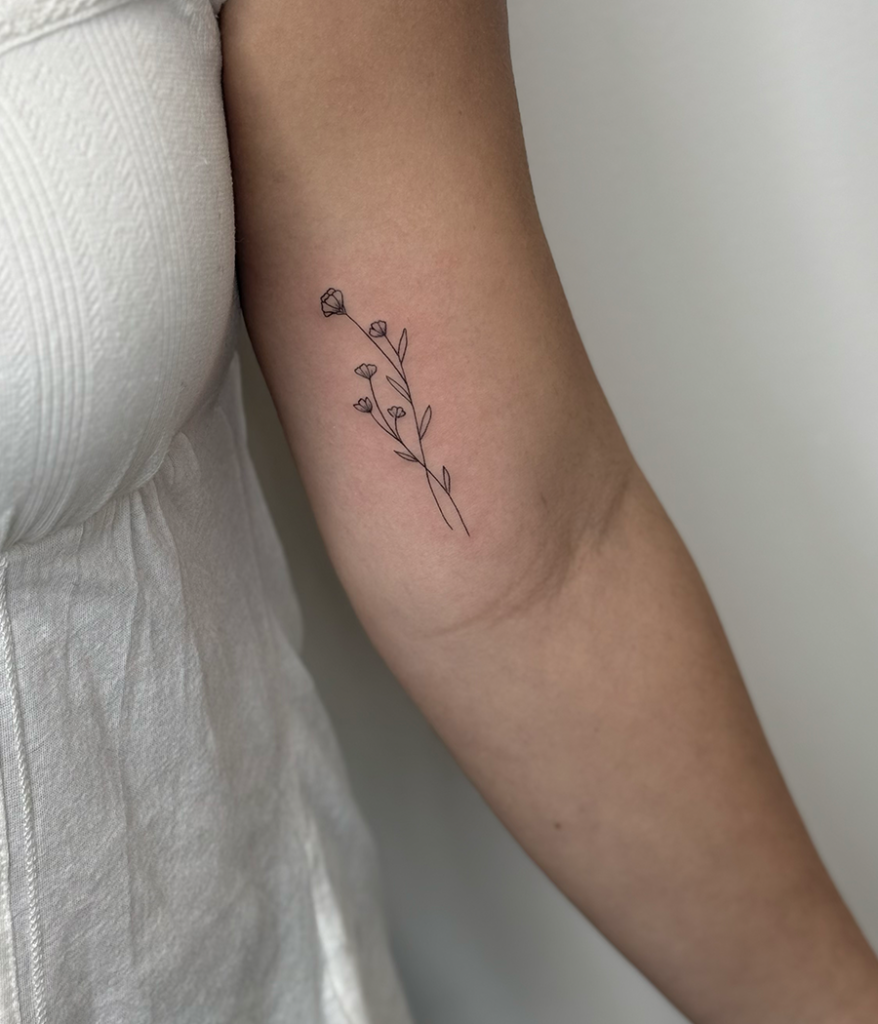 small flower tattoo on inner arm
