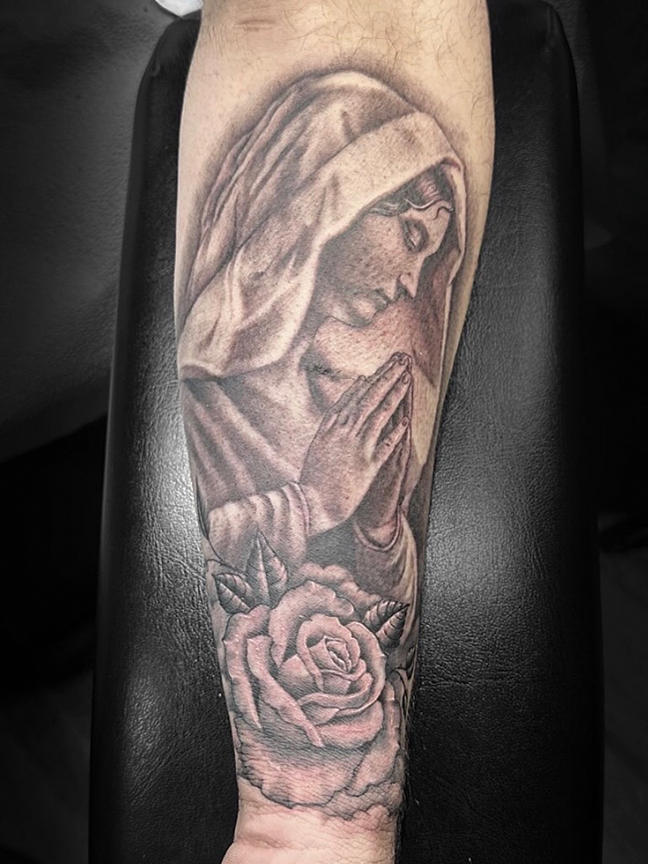 Praying female portrait tattoo on arm