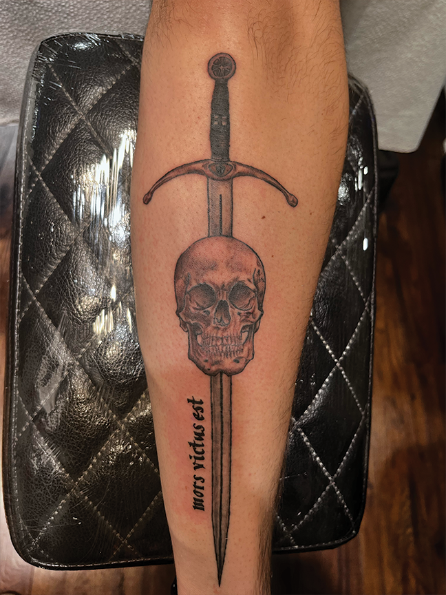 skull and sword tattoo on leg