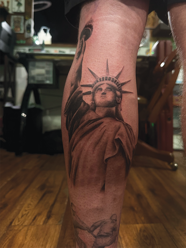liberty statue tattoo on leg