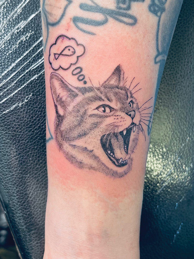 Howling cat tattoo on forearm